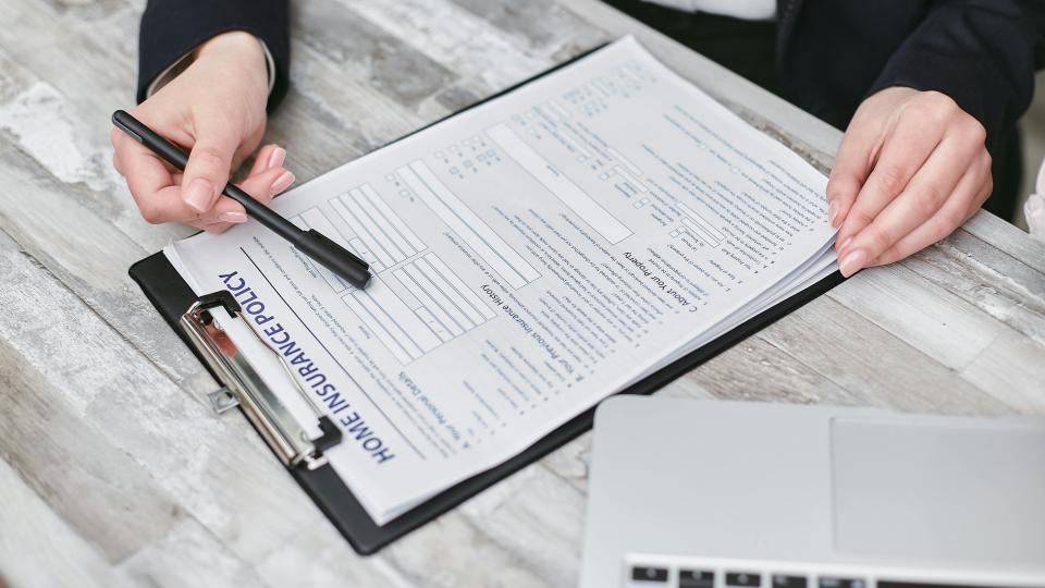 persona leyendo el contrato de un seguro del hogar